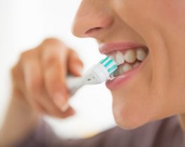 Closeup on young woman brushing teeth